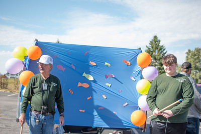 Cougar Electric Car sponsor, Mr. Wilson, and Junior member, Landon Kiepher, run the Electric Car trunk. Set up for a game, attendees are able to fish for a prize