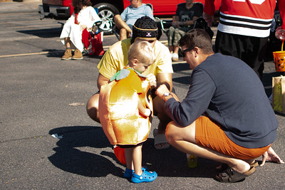 Kennedy High School Student Government Sponsor, Mr. Hollander, fist bumps a kid dressed as a pumpkin.