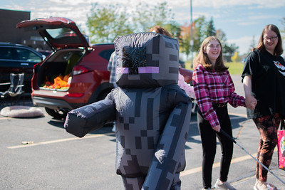 An attendee dressed as an Enderman, waves to their friend.