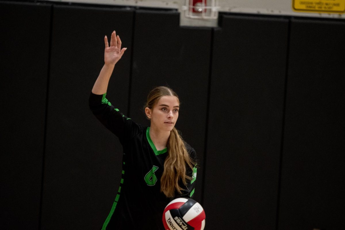 In the serving position, senior Riley Schaldecker prepares to hit the ball. The serve was returned with an out-of-bounds hit from Washington High School which scored Kennedy a point.