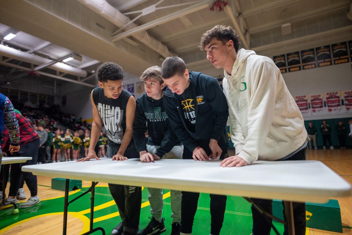 Arranging Kennedy facilitators by age, sophomores Kenny Wade, Carver Miller, Dino Meek, and Jake Sheck work together to submit a final answer.