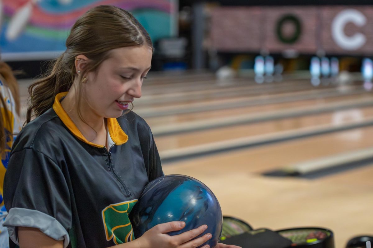 Cleaning her bowling ball, senior Elaina Chesmore prepares for the match. 