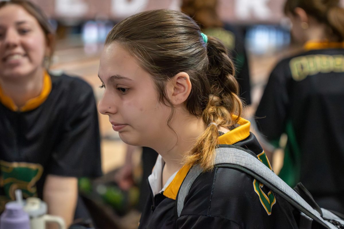 Senior Lily Bader, surrounded by teammates, reflects on her previous throw. 