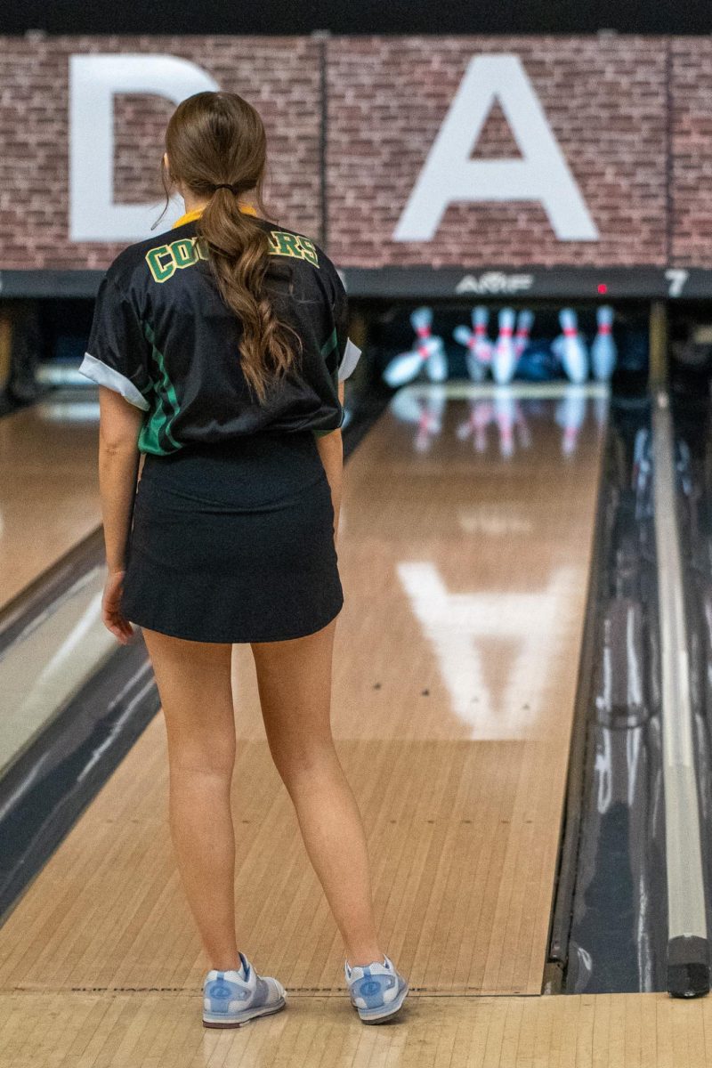 Throwing a strike, senior Elaina Chesmore watches the pins fall. 
