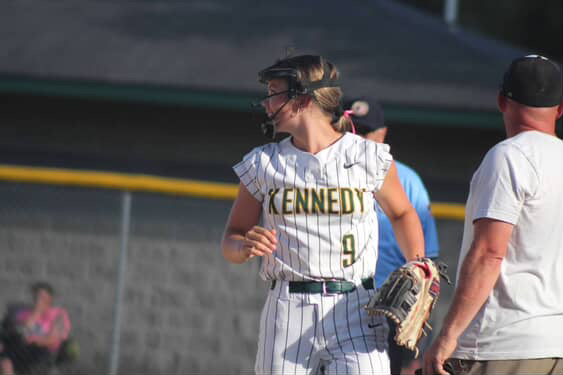 Looking toward the dugout, freshman Quinn Wagner prepares for the next play while on the field during a Kennedy softball game.