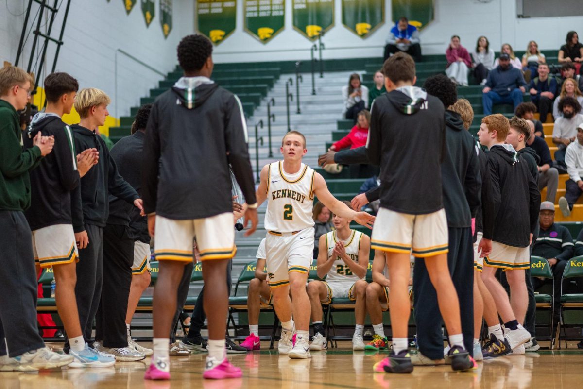 High-fiving his teammates, freshman Drew McKowen checks into the game.