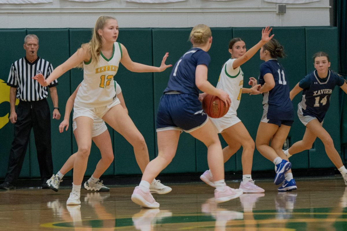 Guarding all around, senior Sophie Johansen and sophomore Katelyn Moser prevent Xavier from scoring.