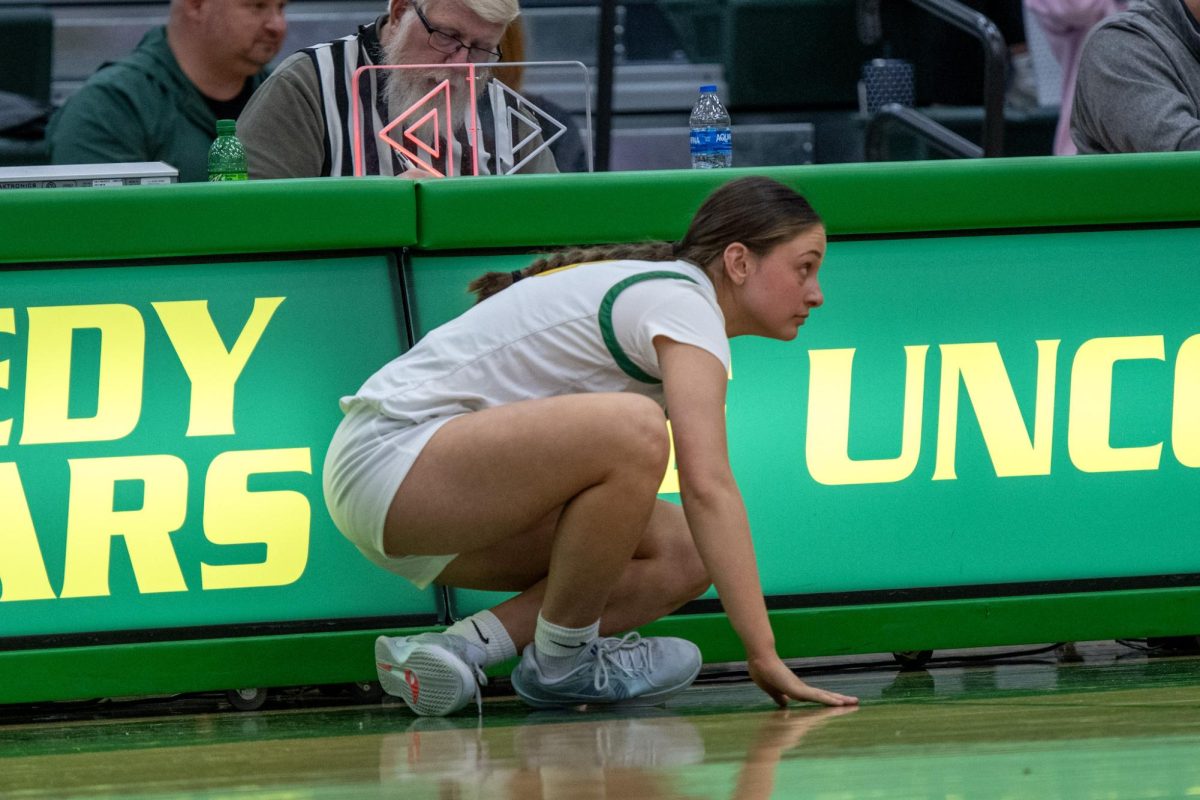 Preparing for the substitution, senior Emily Brandt crouches next to the court.