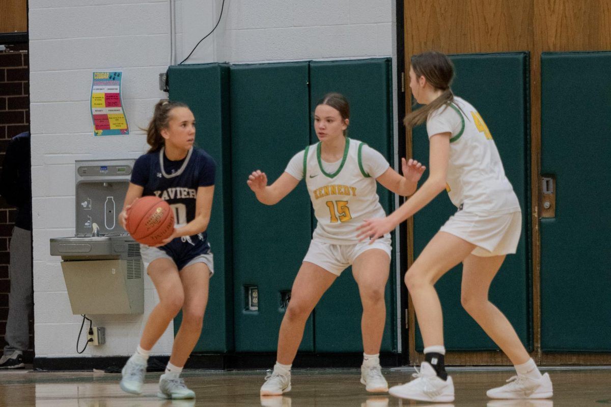 Defending the hoop, freshmen Quinn Wagner and Alli Strasburger block the Xavier player's path.