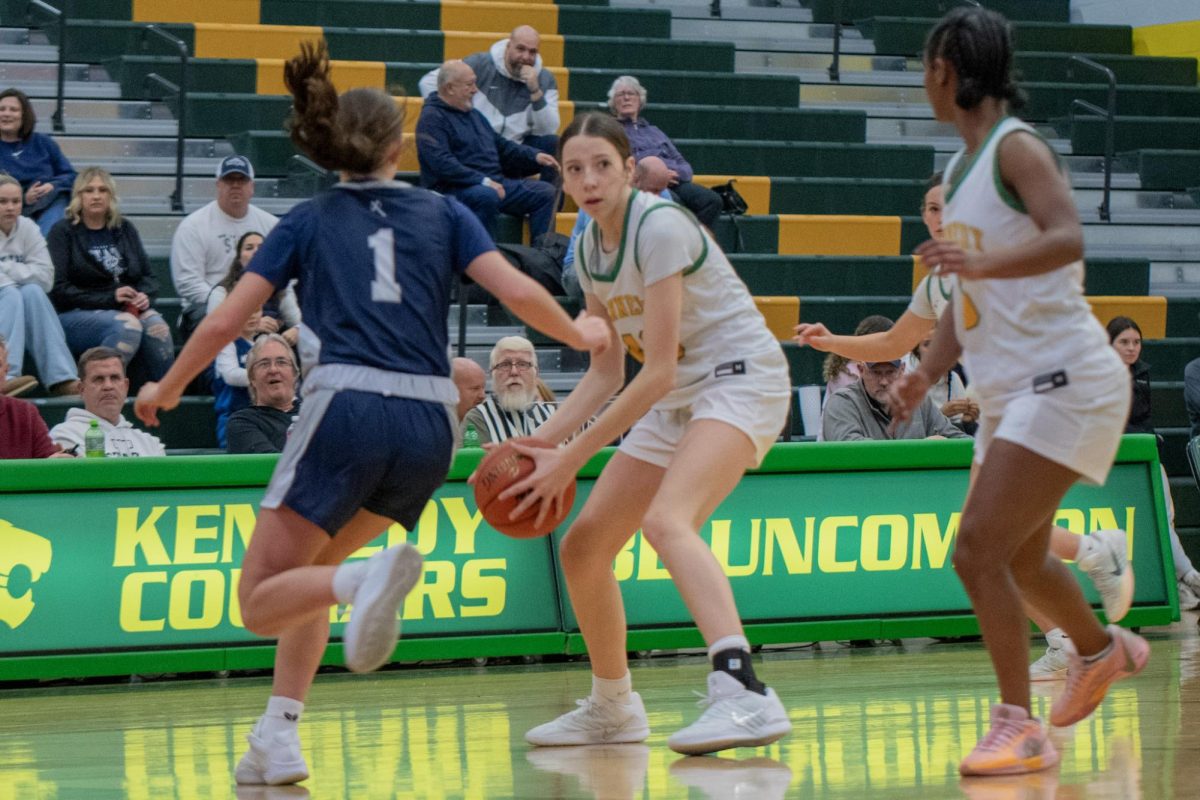 Protecting the ball, the freshman Alli Strasburger looks for someone to pass the ball to .