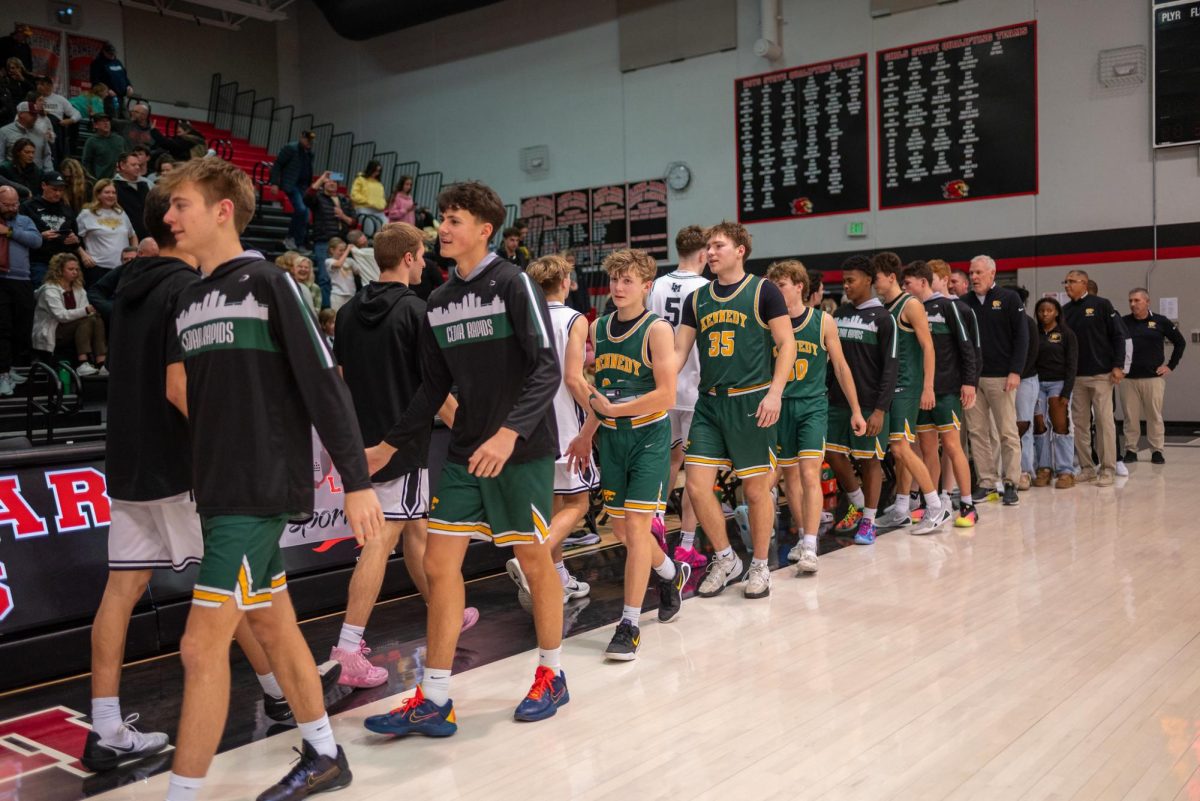 Walking off the court after defeating the Lions 72-68, the Kennedy Varsity Boys basketball team shake the hands of Linn Mar players.