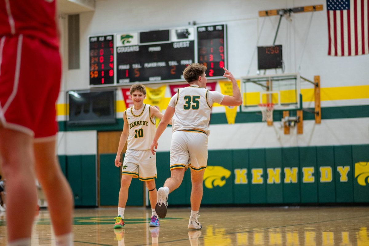 Posing in front of the home crowd, senior Jacob Solberg celebrates after hitting his first three pointer of the game.