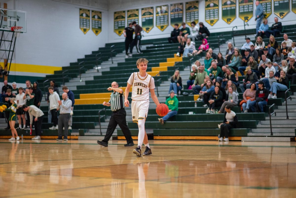 Dribbling out the final seconds of the game, junior Nathan Link walks off the court smiling after a 73-53 win for the Cougars on senior night.