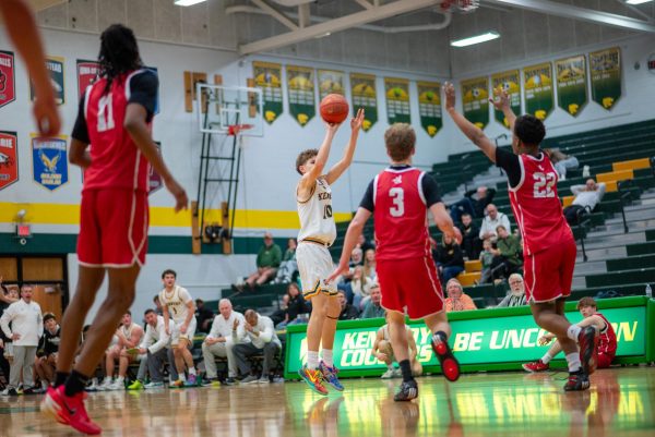 Shooting from the top of the key, freshman Kaden Gomez evades the pressure from City High defenders.