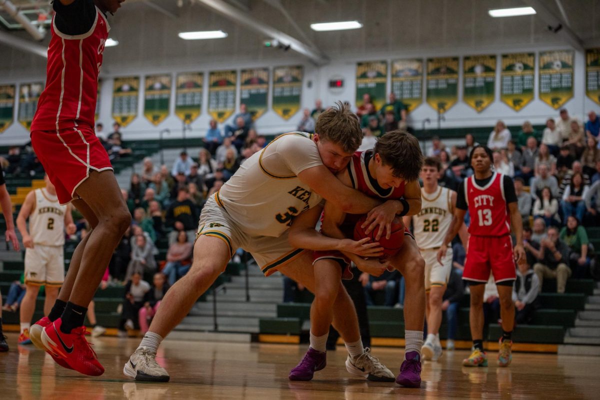 Senior Jacob Solberg reaches for the ball as the Iowa City High player fights back for the ball.  