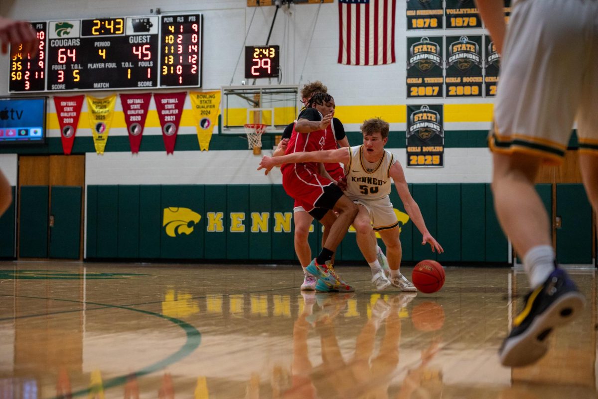 Junior Lawson Neighbor dribbles past two Iowa City High defenders.