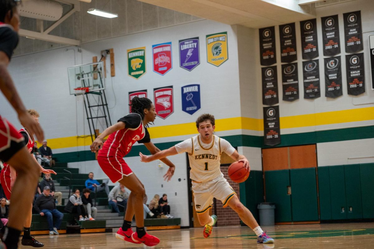 Junior Jaxson Bean jukes out an Iowa City High defender while dribbling to the basket.
